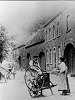 De Poststraat rond 1905. Op de voorgrond zien we de heer Thei Beckers en mevrouw A. Roberts-Leunissen die tijdens het onderhoud van de scharenslijper in het cafe van Kleus Leunissen dit kiekje lieten maken. Het beeld in deze straat is geheel veranderd. Van de poorten die hierop te zien zijn bestaat er slechts nog een alle woningen zijn inmiddels verbouwd.