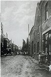 De Dorpstraat. Later werd deze weg die liep vanaf cafe "Op den Hoek tot de Kniekuilenweg in Kerkstraat omgedoopt. De naam Kerkstraat en Valderenweg zijn van latere datum.
Deze foto van rond 1930 laat de eerste electriciteirspalen zien. De draden liepen bovengrond en vooral als men met de vaak hoog opgestapelde hooi en stro-wagens door de straat reed vormden deze een obstakel. Regelmatig viel de stroom dan ook uit of werd deze uit voorzorg uitgeschakeld. Veel huizen hadden in die tijd slechts een lichtpunt dat tussen de woonkamer en de keuken was opgehangen in een gat dat hiervoor speciaal was gemaakt. Op deze foto zien we cafe Bus en het huis Quix Anna Hennen en Victorine Mengelers. Zittend op de stoep Harie Hennen. Aan de overkant het huis van de familie Olieslagers. Zij hadden als eersten in Doerade een luxe auto.