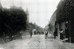 Kerkstraat 45 in die tijd  1925 nog Dorpstraat genaamd.
Hier woonden Anna en Frans Offermans zij staan voor hun boerderij. Op de voorgrond, met strohoed, Zef Dassen. De Kerk was omgeven met een hoge muur. Het Warblingshuis had een soort torentje.