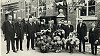 het 25 jarig ambtsjubileum van Burgemeester J.H.H. Pijls op 15 oktober 1928 werd feestelijk gevierd. Op de foto v.l.n.r. secretaris Krijnen, wethouders Stevens en Canisius, Jan Janssen, mevrouw Pijls, Jan Petri, Burgemeester Pijls, K. Damoiseaux, dochter en schoonzoon Delhougne, veldwachter J. Janssen, G. Houtvast en G. Pijls, gemeenteopzichter. Geposeerd wordt voor het toenmalige gemeentehuis, thans eetgelegenheid Dowij. Links op de foto zijn nog het arrestantenlokaal en de brandweerkazerne met aanplakkastje zichtbaar.